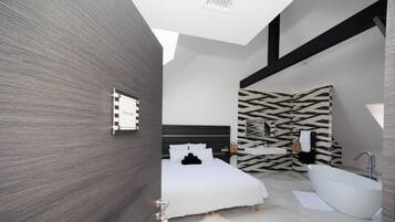 A modern bedroom with a large bed, a white bathtub, and a zebra-patterned wall.