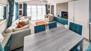 Un salon moderne comprenant un canapé, une table à manger et un téléviseur.