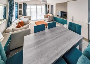 A modern living room with a sofa set, a dining table, and a TV. - Superior 2 Bed Lodge (14ft wide) (Haverigg, Millom)