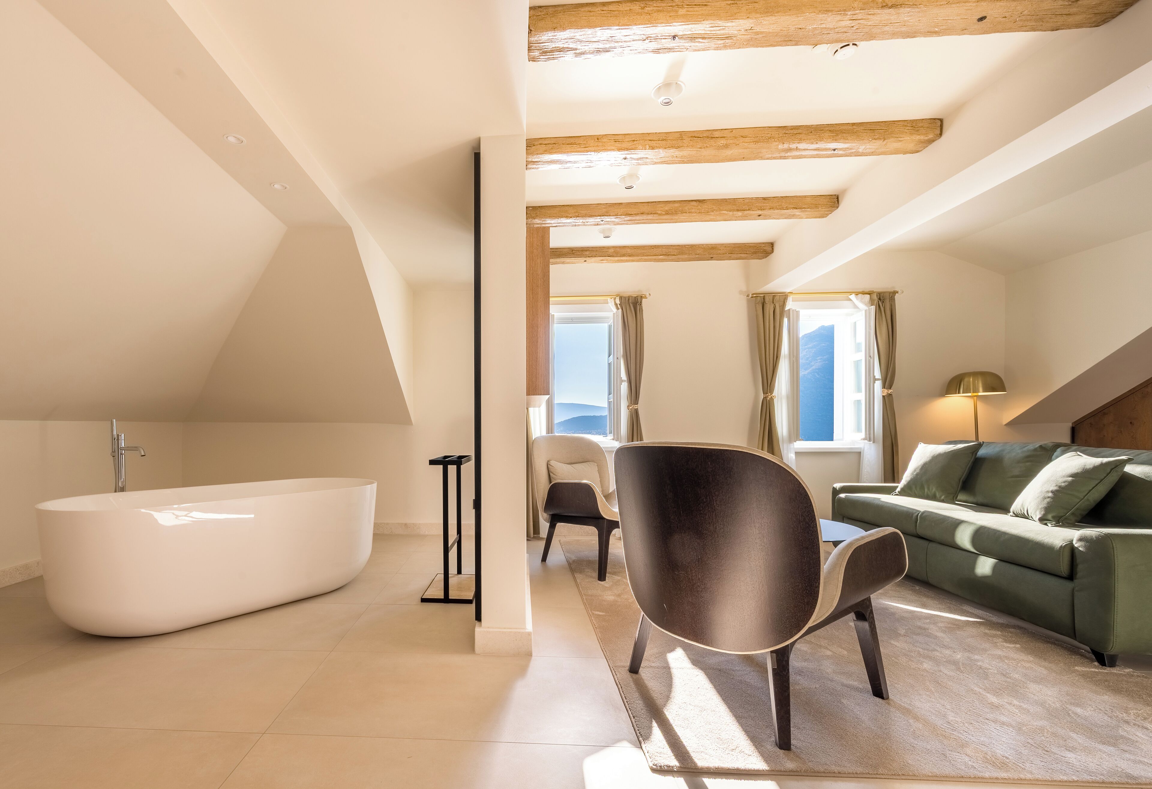 Ein modernes Wohnzimmer mit einer großen Badewanne, einem Sofa und einem Sessel.