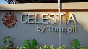 Schild für "CELESTIA by Thoppil" mit Logo und etwas Grün im Vordergrund.