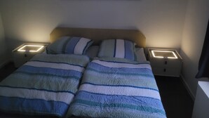 A hotel room with a bed, two bedside tables with illuminated lamps, and a cityscape painting on the wall. - Cozy apartment with central location directly at the market in Hainichen (Hainichen)