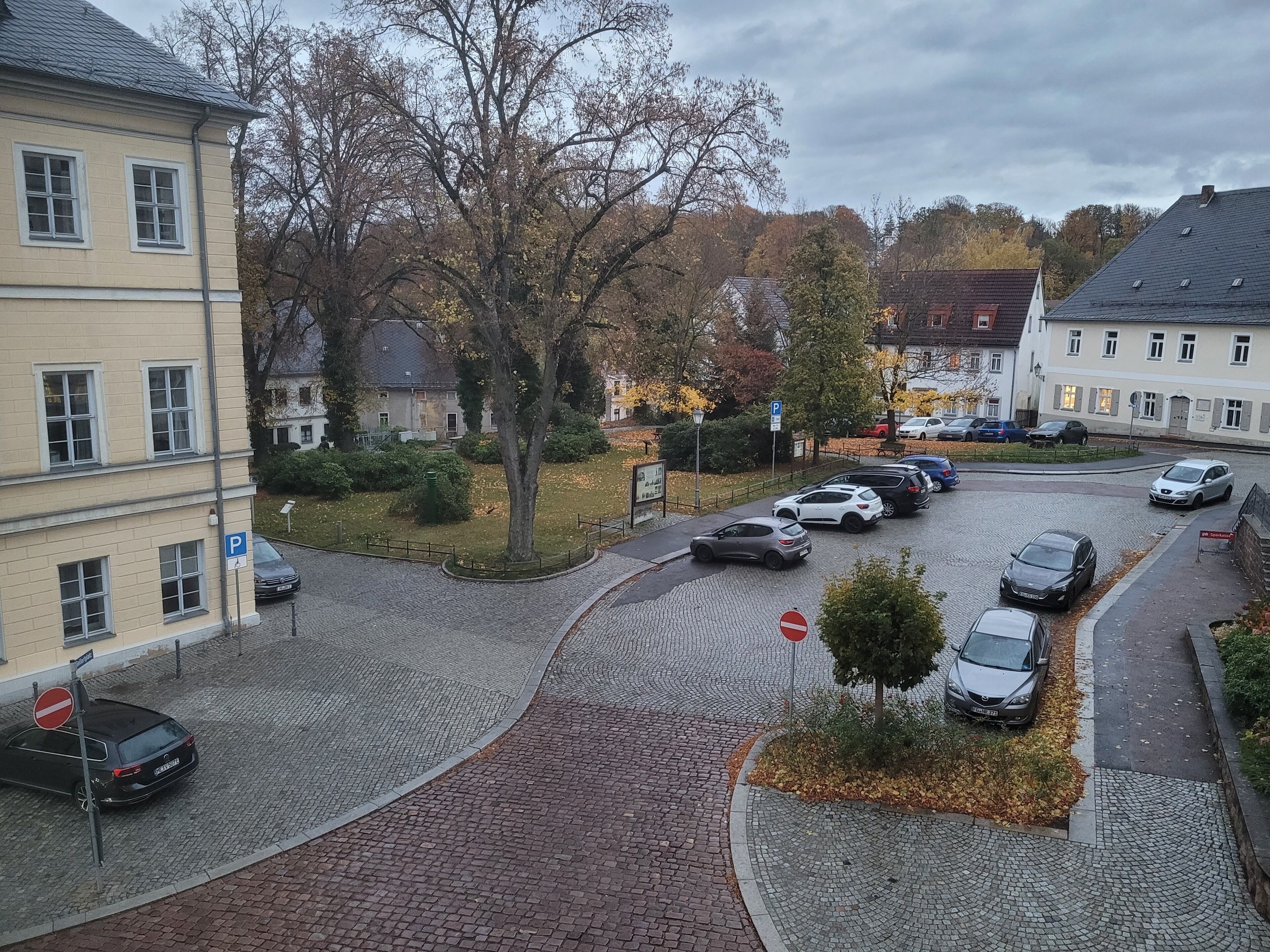 Een straat met keien, parkeerverf en gebouwen aan beide zijden.