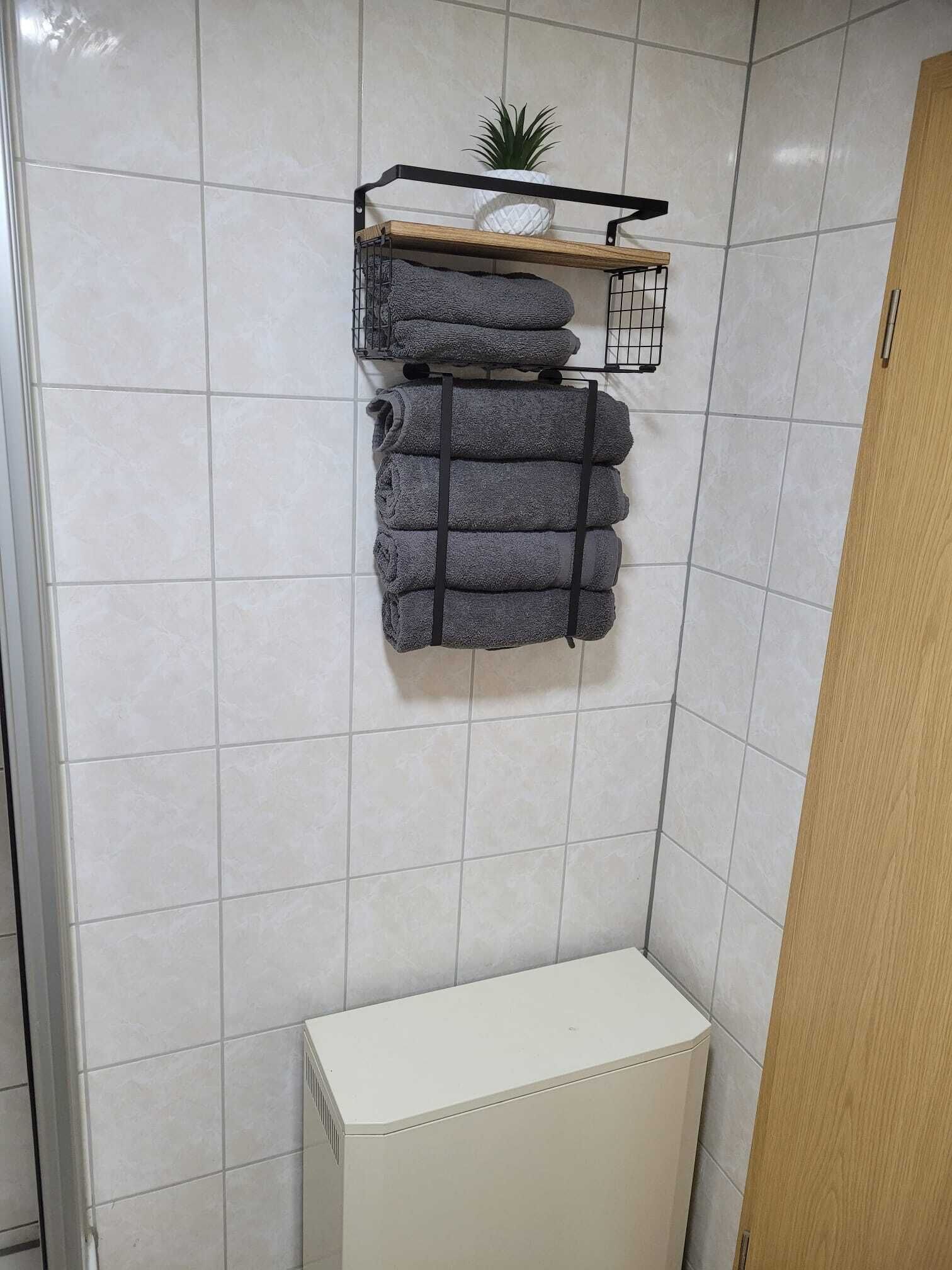 A bathroom with white tiled walls, a white radiator, and a wooden door.