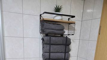 A bathroom with white tiled walls, a white radiator, and a wooden door.