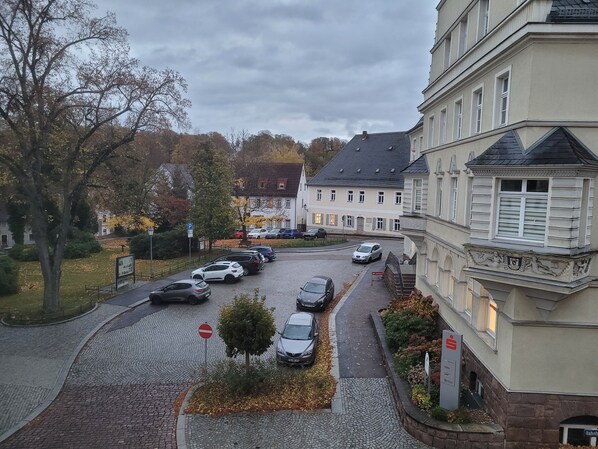 A street view with parked cars, a no entry sign, and buildings with classical architecture.