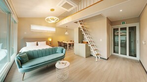 A modern hotel room with a bed, a sofa, a dining area, and a staircase. - Gyeongju Sky Flower Astro Pool Villa (Gyeongju)