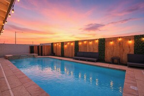 A swimming pool with a wooden fence and string lights, surrounded by a patio area with seating. - 3-bedroom house in fabulous Las Vegas (Las Vegas)