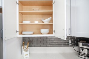 A kitchen with open cabinets containing white dishes and a knife block. - 3-bedroom house in fabulous Las Vegas (Las Vegas)