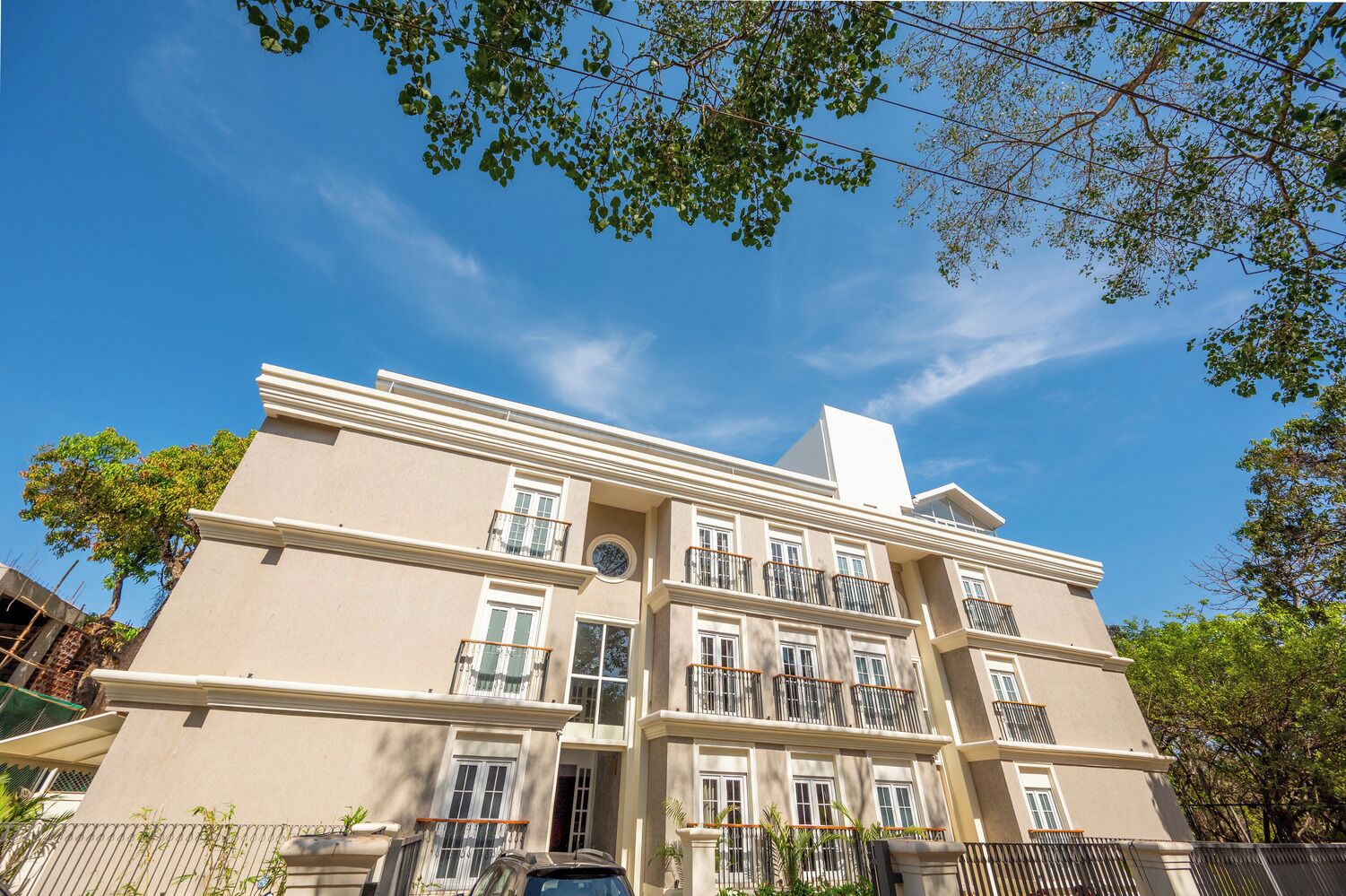 A multi-story building with a symmetrical facade, multiple balconies, and a central entrance.