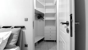 A bedroom with a bed, a nightstand, a bedside table, a wardrobe, and a built-in bench. - Leonidas View (Sparta)