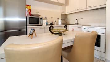 Departamento, vista a la ciudad | Cocina privada | Refrigerador, microondas, horno y cafetera y tetera