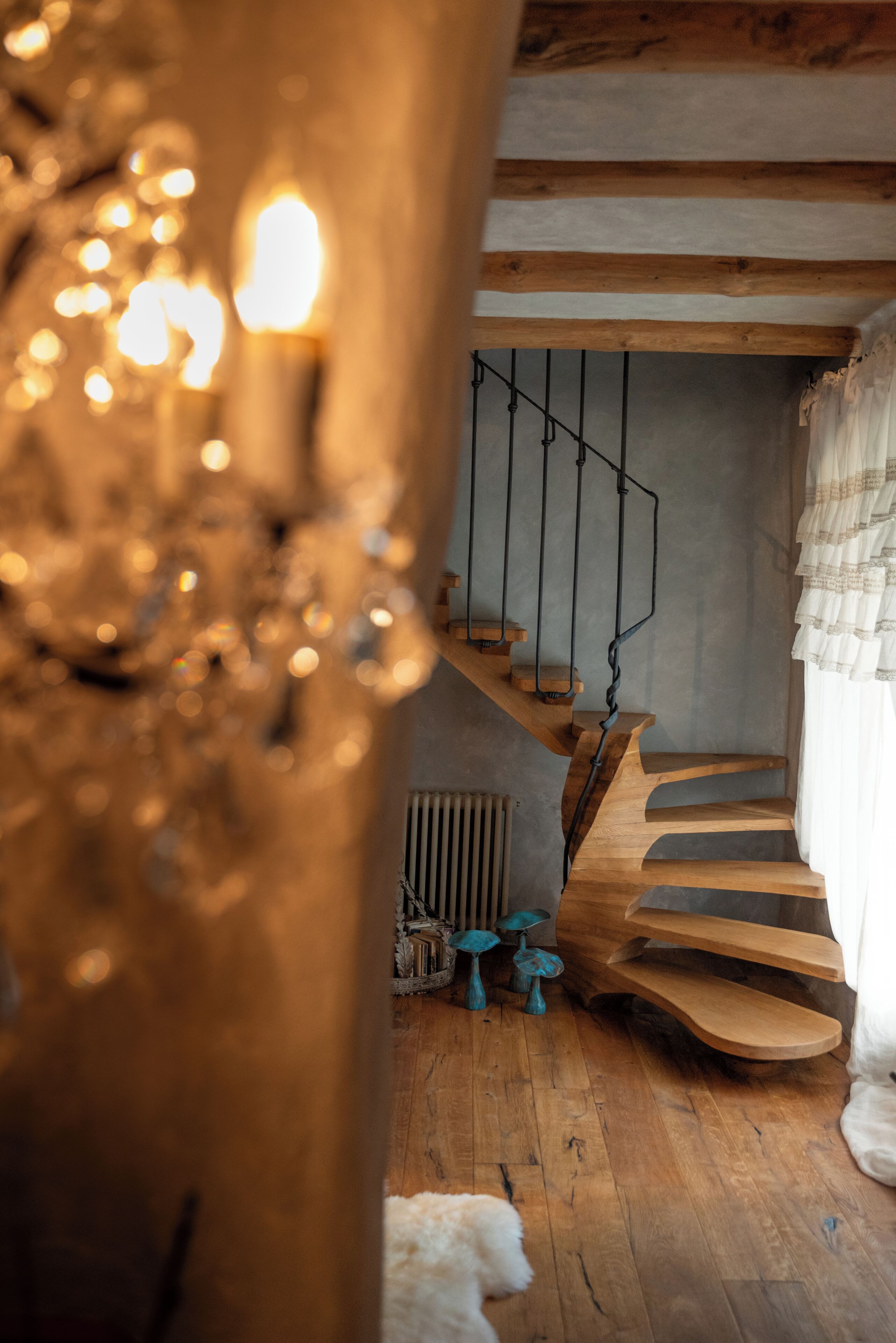 A wooden staircase with a metal railing, a radiator, and a white fluffy object on the floor.