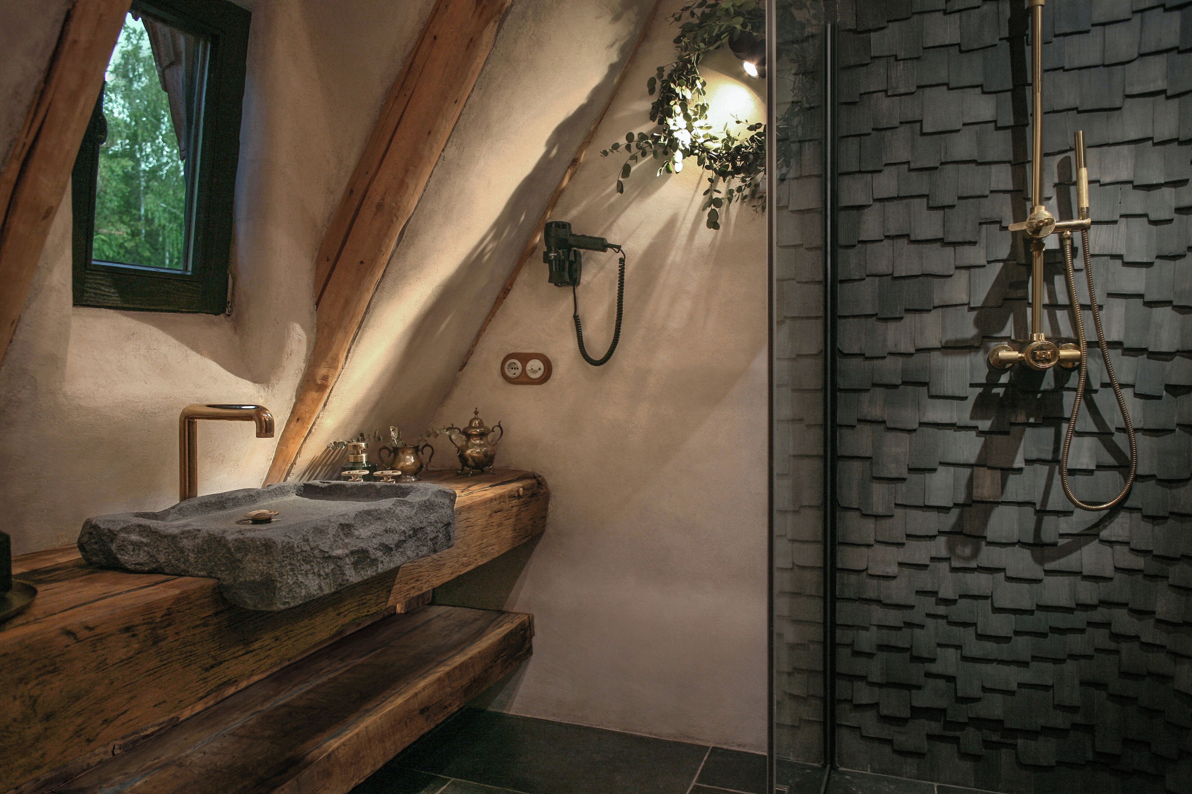 A bathroom with a stone sink, wooden countertop, and a shower with a textured wall.