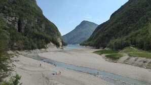 Un río serpentea por un valle, flanqueado por montañas a ambos lados.