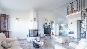 A spacious living room with a fireplace, a dining area, and a kitchen. - Villa Caroline with pool and view (Imperia)