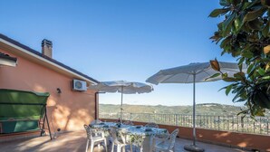 An outdoor patio with a table and chairs, surrounded by white umbrellas, and a view of hills in the background. - Villa Caroline with pool and view (Imperia)