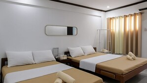 Habitació d'hotel amb dos llits individuals, una taula de nit amb una làmpada, un mirall i una finestra amb cortines.