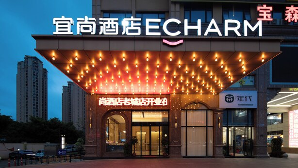 A hotel entrance with a marquee sign, a large arched doorway, and a modern building facade. - Yishang Hotel  (Chengmai)