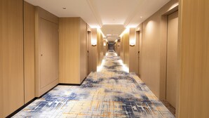 A hotel hallway with wooden walls and a patterned carpet. - Yishang Hotel  (Chengmai)