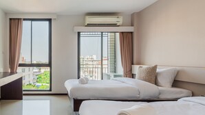 A hotel room with two beds, a desk, and a large window with curtains. - ZAYN Bangna Hotel (Bangkok)