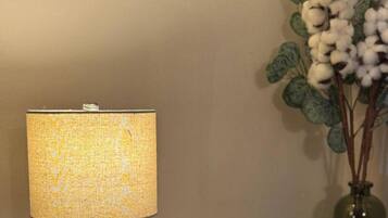 A lamp with a textured fabric shade against a plain wall.