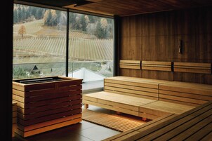 A modern interior with a wooden bench, a built-in bench, and a sauna area.