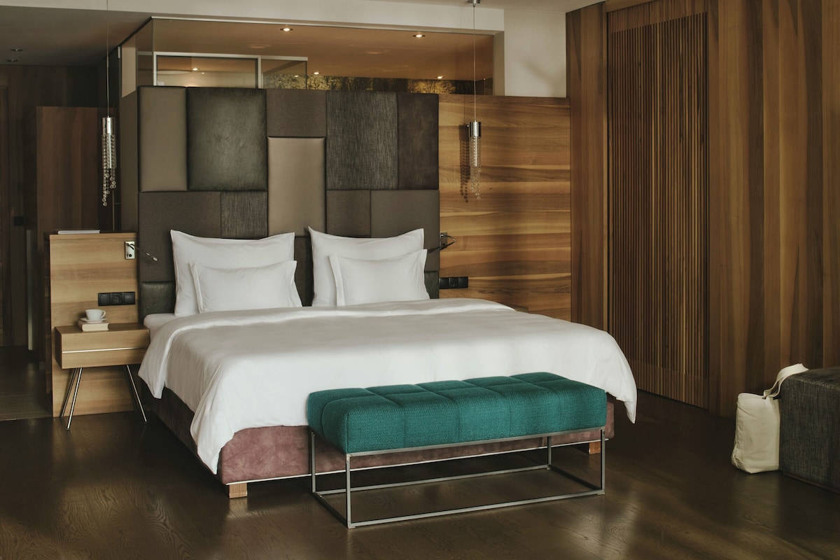 Quarto moderno com uma cama grande, mesa de cabeceira e guarda-roupa embutido.