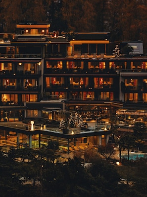 A multi-story hotel with balconies, a swimming pool, and outdoor seating areas. - Alpiana Resort (Lana)