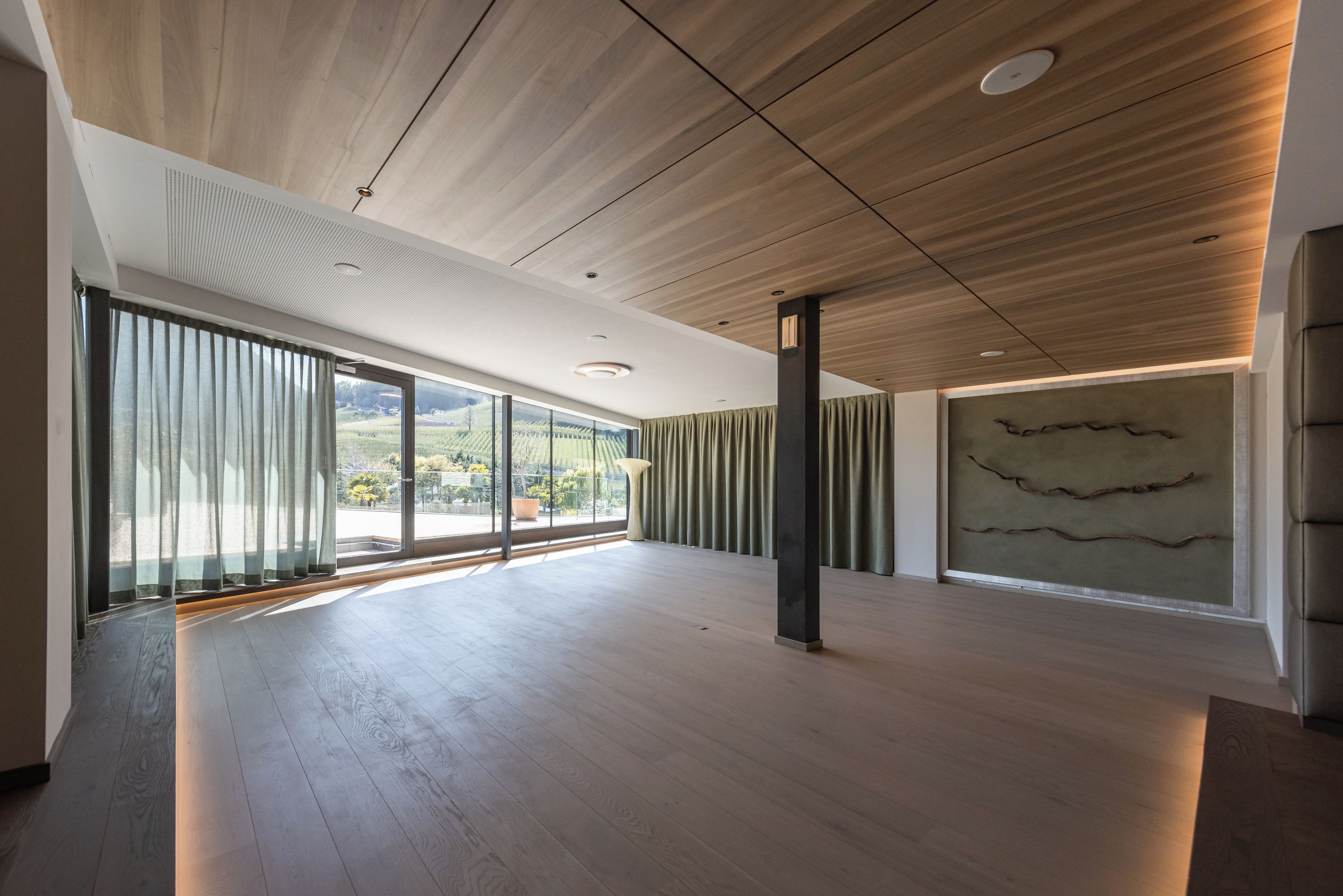 Een ruime kamer met een hoge plafond, grote ramen en een minimalistisch design.