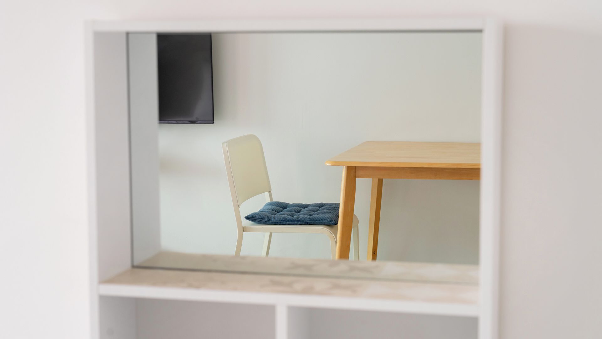 A small, enclosed room with a single chair and a table.