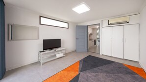 A modern living room with a flat-screen TV, a white entertainment unit, and a large wardrobe. - The Seaside Taean (Taean)