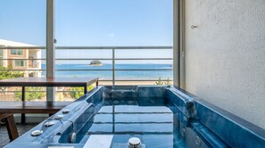 A hot tub with a view of the ocean and a balcony with a table. - The Seaside Taean (Taean)