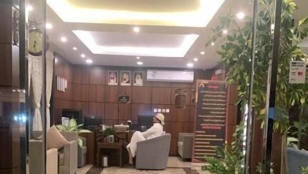 A hotel entrance with a reception desk, seating area, and a sign indicating the entrance. - Danat Al Sharq Serviced Apartments (Al Khobar)