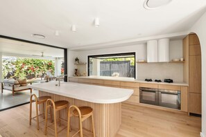 Una cocina moderna con una isla grande, armarios de madera y electrodomésticos de acero inoxidable.