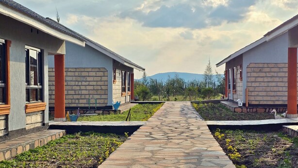 Un sendero que conduce a dos edificios modernos con fachadas de ladrillo y detalles de madera.