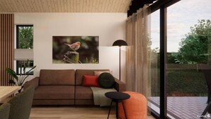 A modern living room with a wooden ceiling, a brown sofa, a dining table, and a large window offering a view of greenery outside. - 6-person holiday home for relaxing retreat. (Balkbrug)
