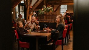 A cozy restaurant with wooden beams and red chairs. - 6-person holiday home for relaxing retreat. (Balkbrug)