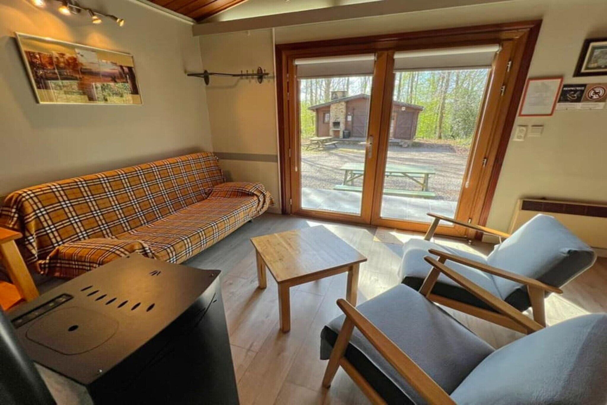 Een knus vertrek met een geruite bank, een klein houten tafeltje en twee fauteuils.
