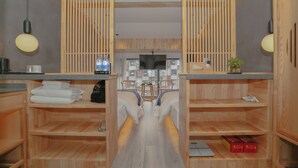A modern bathroom with wooden shelves, a central sink, and a large mirror. - Cozy Boutique Hotel (Zhangjiajie)