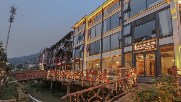 A hotel with a traditional architectural style, featuring multiple stories and large windows. - Cozy Boutique Hotel (Zhangjiajie)