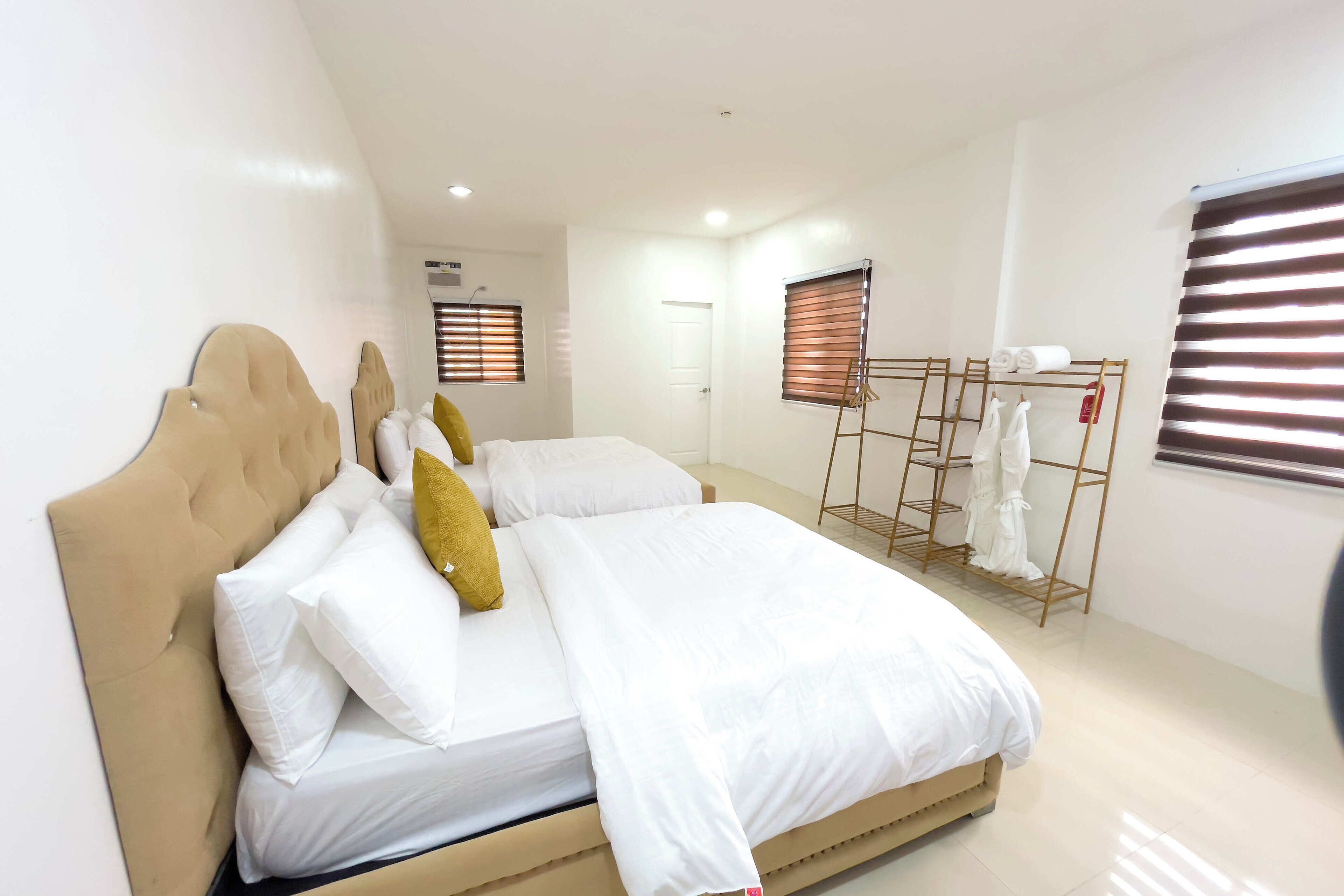 Un dormitorio con una cama grande, un armario y una ventana con persianas.