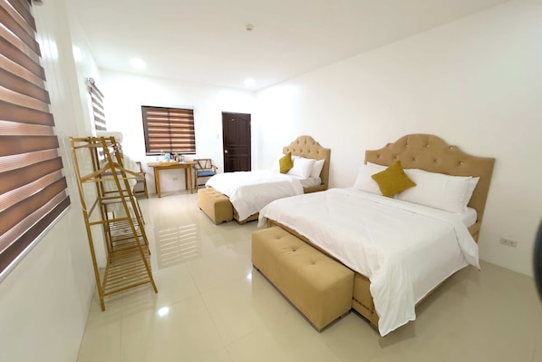 Habitación de hotel con dos camas, un escritorio y una silla.