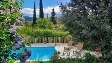 Una piscina al aire libre de temporada, sombrillas, tumbonas