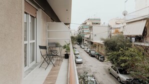 Un balcone con una sedia, un tavolino e una pianta in vaso.