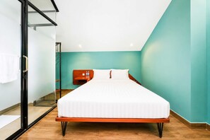 Ein Schlafzimmer mit einem Bett, einem Nachttisch, einer Glastür und tealfarbenen Wänden.