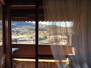 Un balcon avec vue sur la ville et les montagnes.