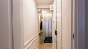 A hotel hallway with a wooden floor, white walls, a blue carpet, and a door with a light switch. - Blue Santa Croce by MMega (Florence)