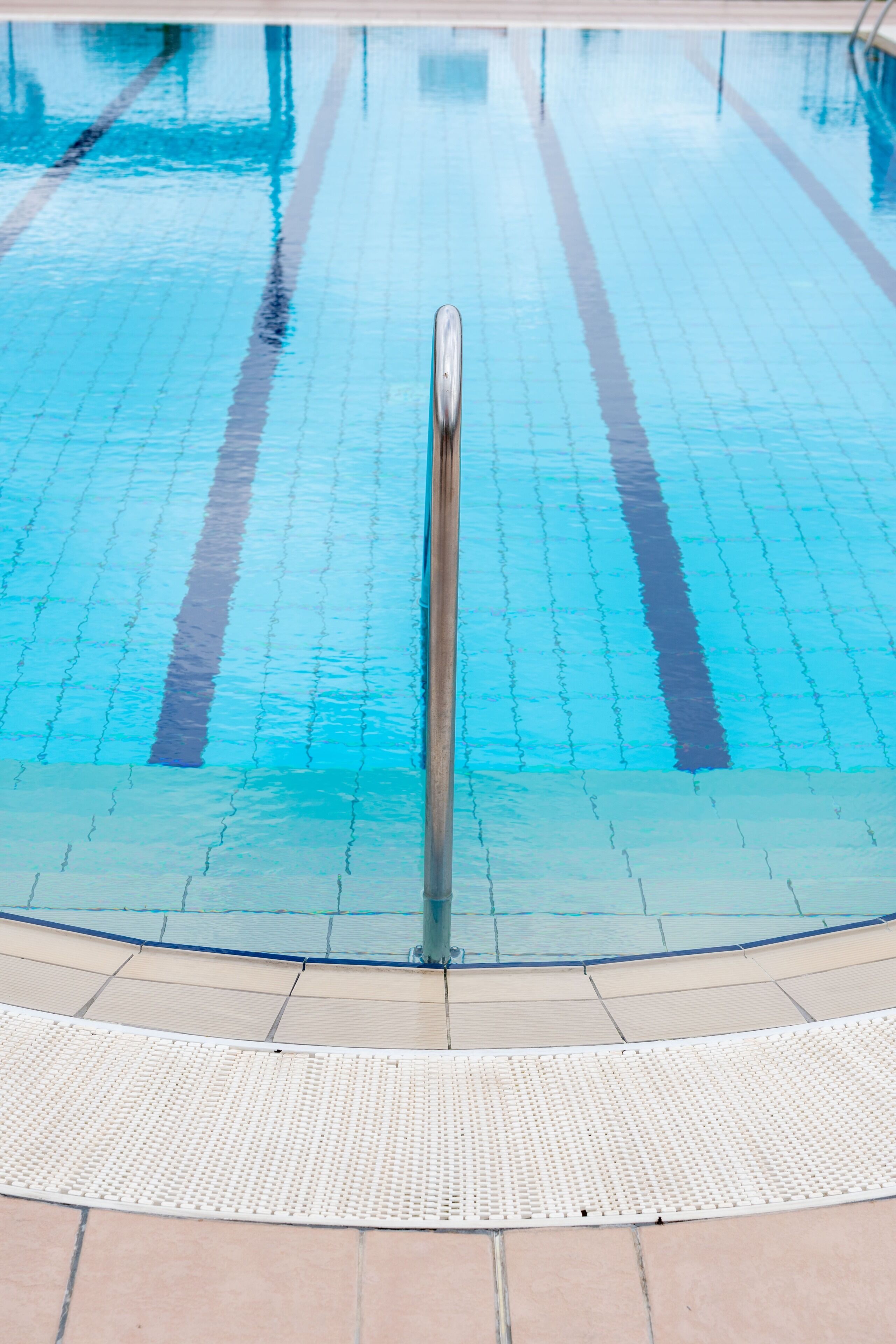 Una piscina con demarcaciones claras para carriles y una barandilla central.