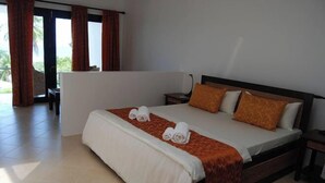 A hotel room with a bed, a nightstand, a chair, and a view of the outdoors. - Panorama de Argao Boutique Resort (Argao)